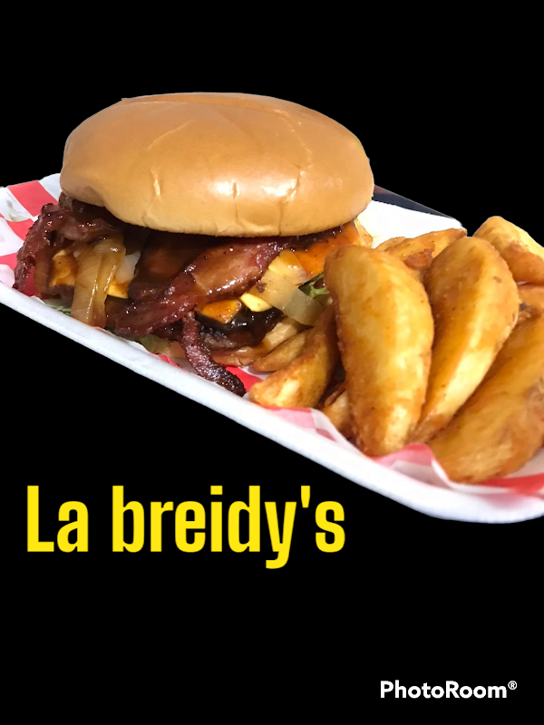 Hamburguesa jugosa con queso fundido y papas fritas crujientes en Breidy's burguers — plano frontal del mostrador iluminado