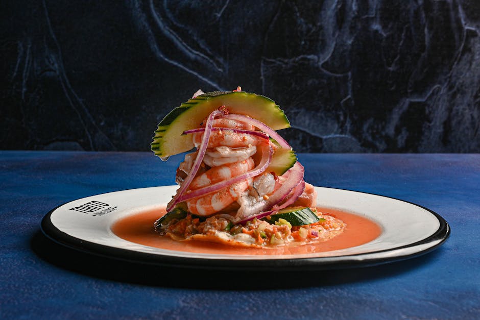 Appetizing seafood tower of shrimp with red onion and cucumber on a plate.