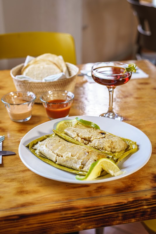 Plato de mole negro de guajolote en Totopo Güero — vista cenital mostrando la salsa brillante, el guajolote desmenuzado y guarnición de ajonjolí