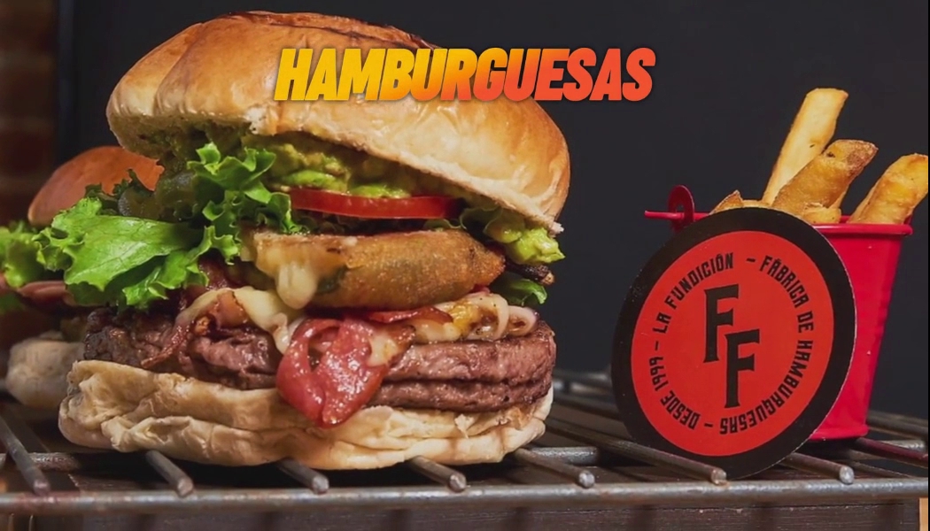 Hamburguesa Fundición Classic en plato de madera, mostrando carne jugosa, queso derretido y salsa de chipotle