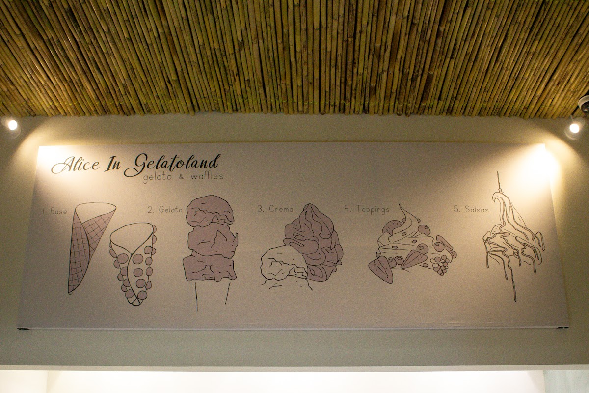Interior con mesas de madera y barra de waffles en Alice in Gelatoland — vista del ambiente