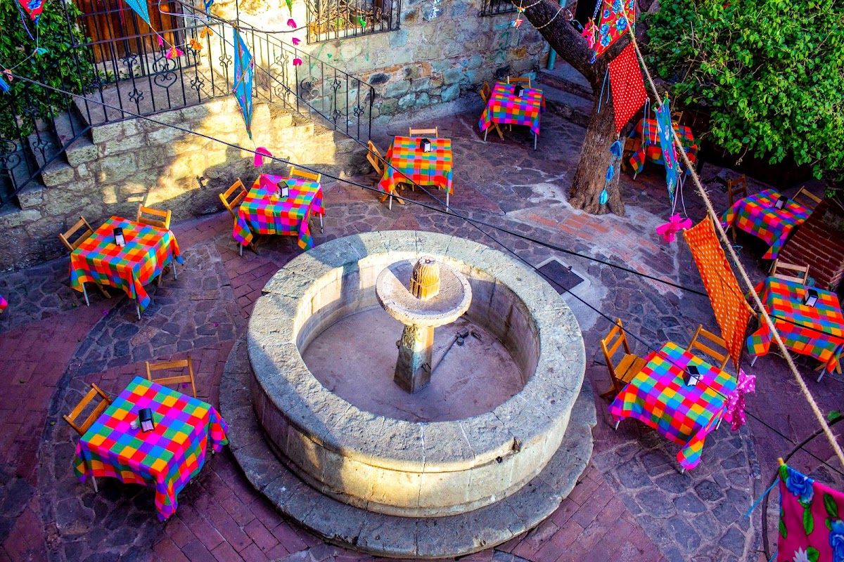 Escena interior con músicos tocando trova, mesas de madera y clientes disfrutando, luz tenue — ambiente bohemio