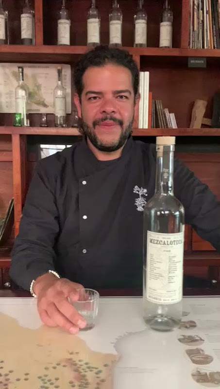El Salón del Despecho – foto del bar con luces rojas y una tabla de nachos en la barra