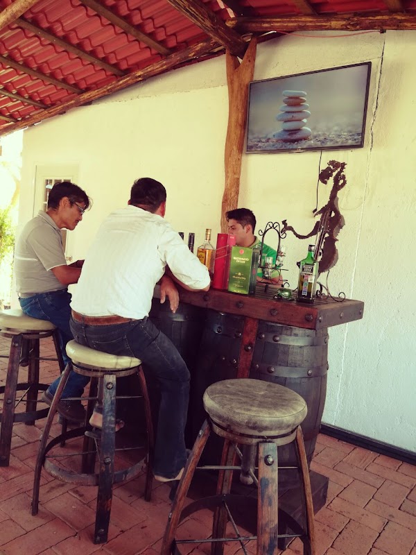 Restaurant Campestre Santo Domingo – mesa con tasajo, chocolate de agua y una botella de mezcal sobre la mesa, interior rústico
