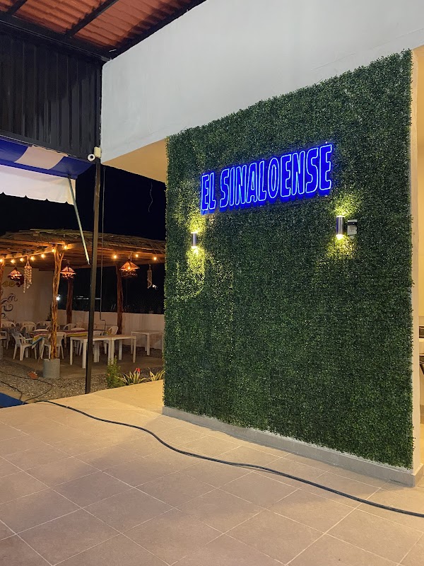 Mariscos El Sinaloense – plato de camarones al ajillo sobre tabla de madera, cerveza fría al lado, ambiente de restaurante sencillo