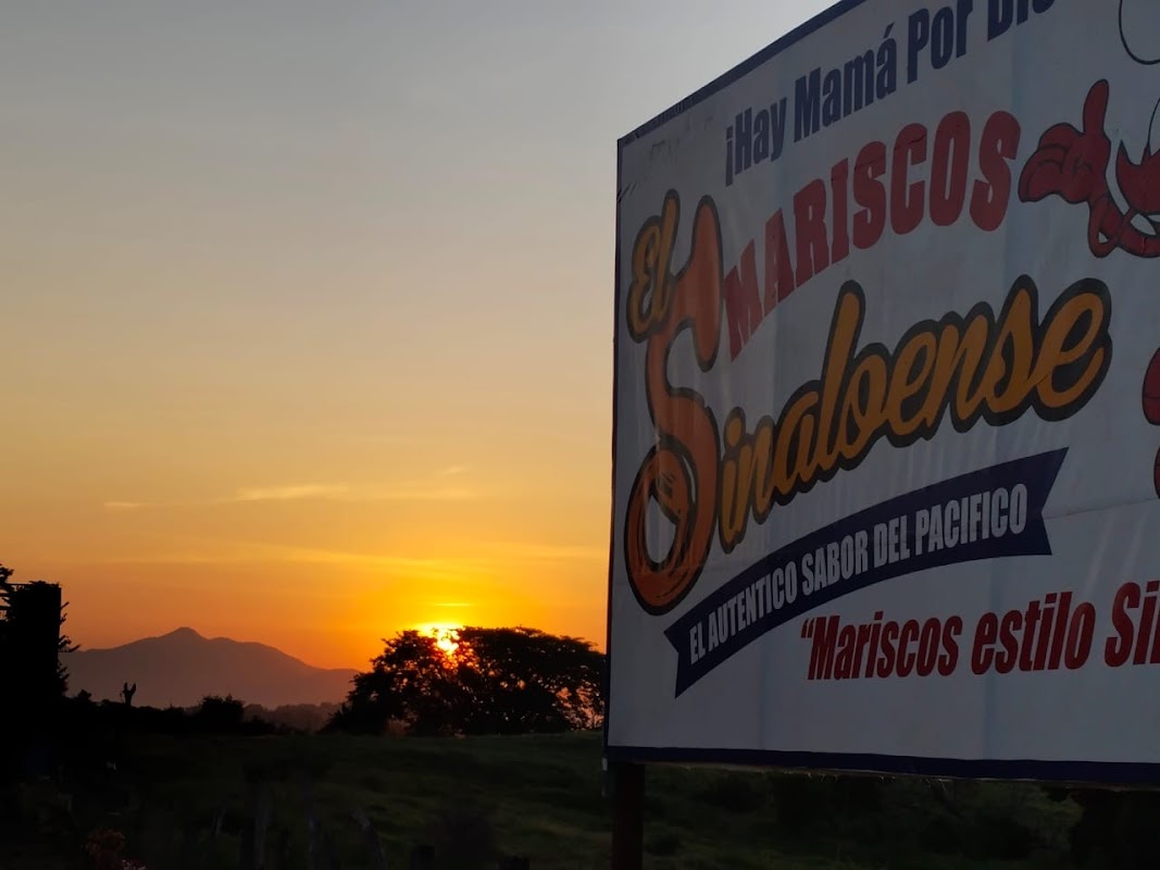 Mariscos El Sinaloense con su terraza al atardecer, mostrando camarones al ajillo y una cerveza bien fría sobre la mesa