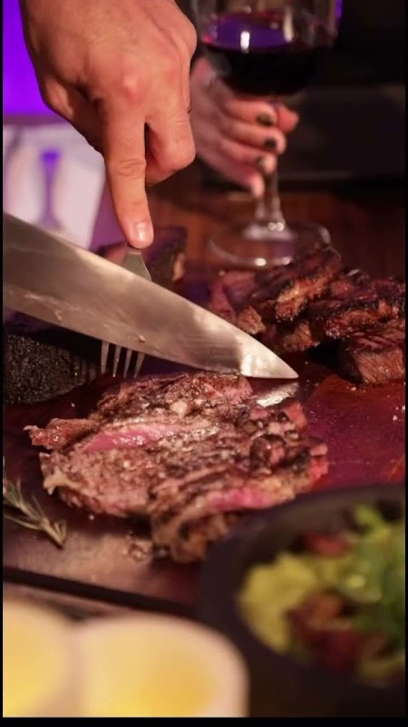 Rib eye tacos con médula ósea en Aborigen — presentación en plato de madera con guarnición