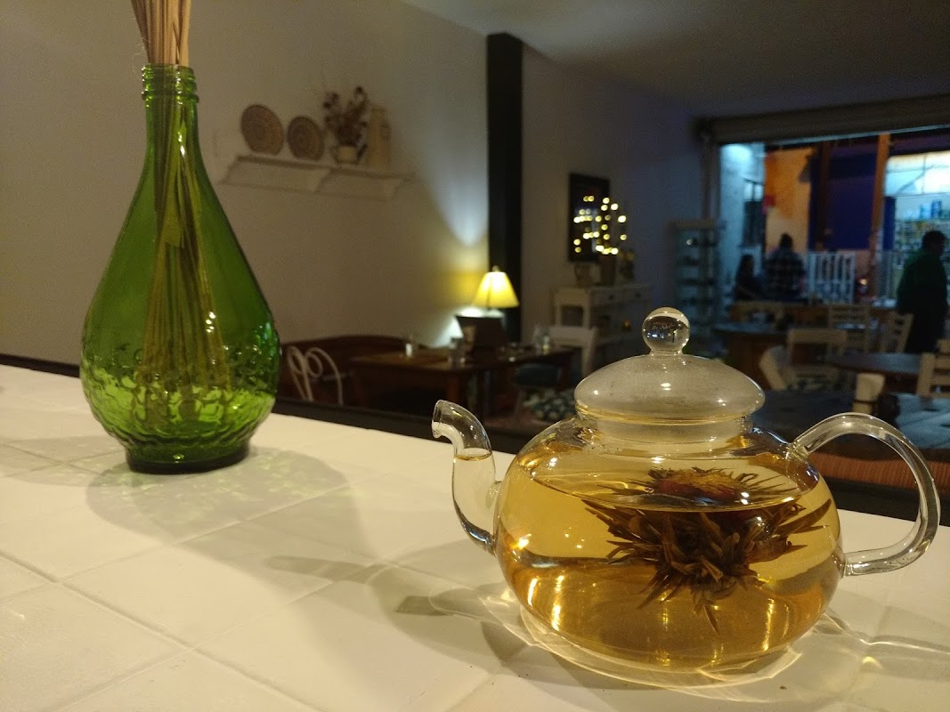 Fachada de Casa de Té Amando-té con su letrero rojo y mesas de madera al frente