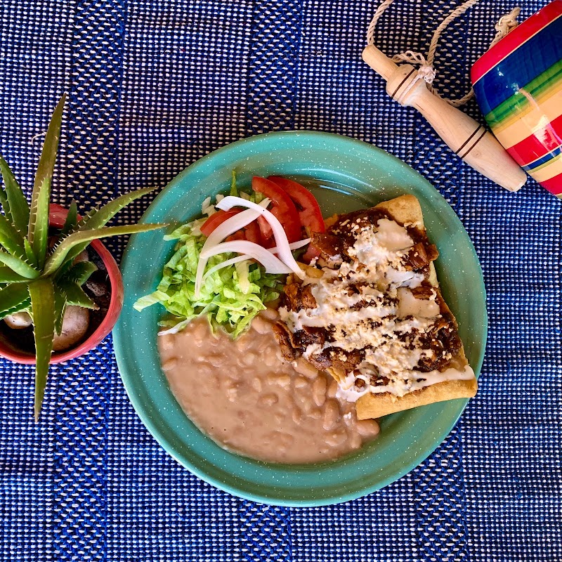 plato de chilaquiles rojos con huevo y salsa en Tarascas Restaurante, vista del plato y parte del mostrador