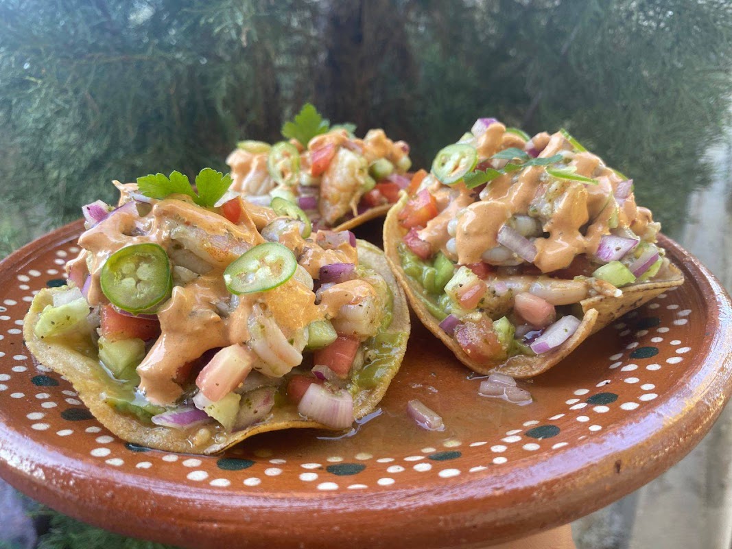 Tacos de camarón y ceviche de pulpo en Marisquería Mar de Lu, con botella de agua de maracuyá al lado