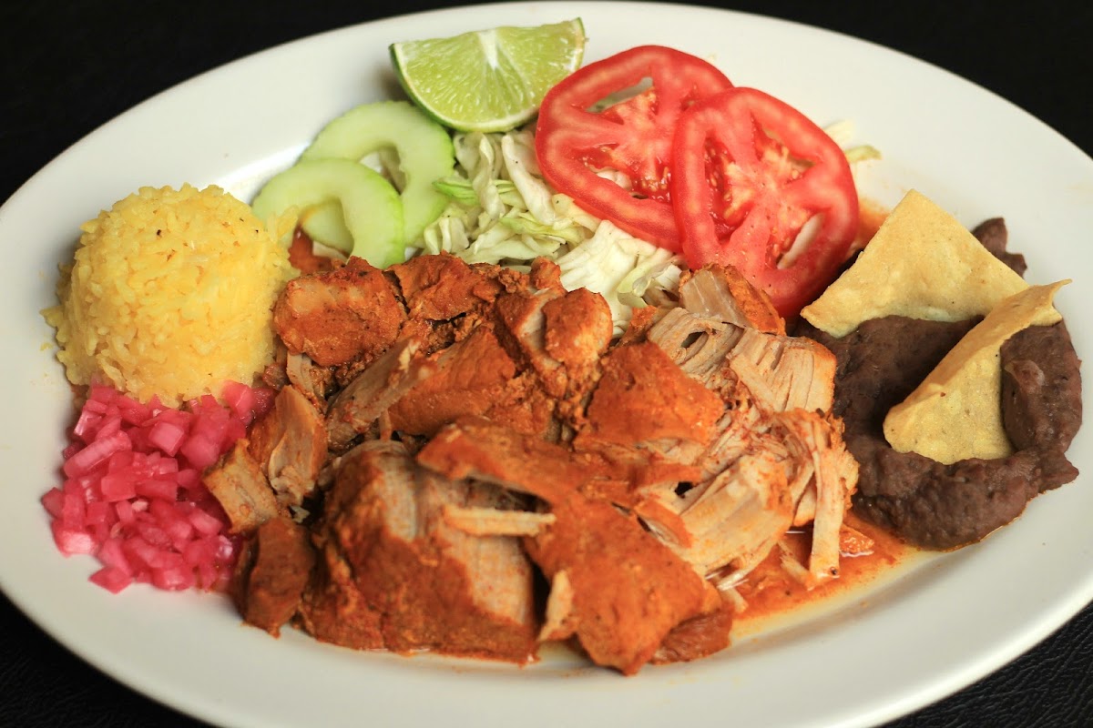 Plato de panucho de camarón y cochinita pibil en Las Mestizas, con salsa de achiote visible