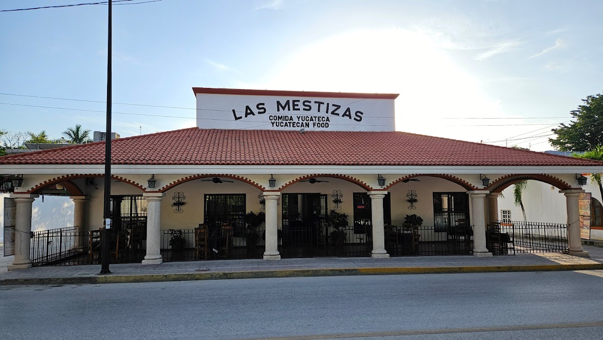 Luna Café exterior con mesas al aire libre, mostrando una taza de café y un crepe de frutas en primer plano