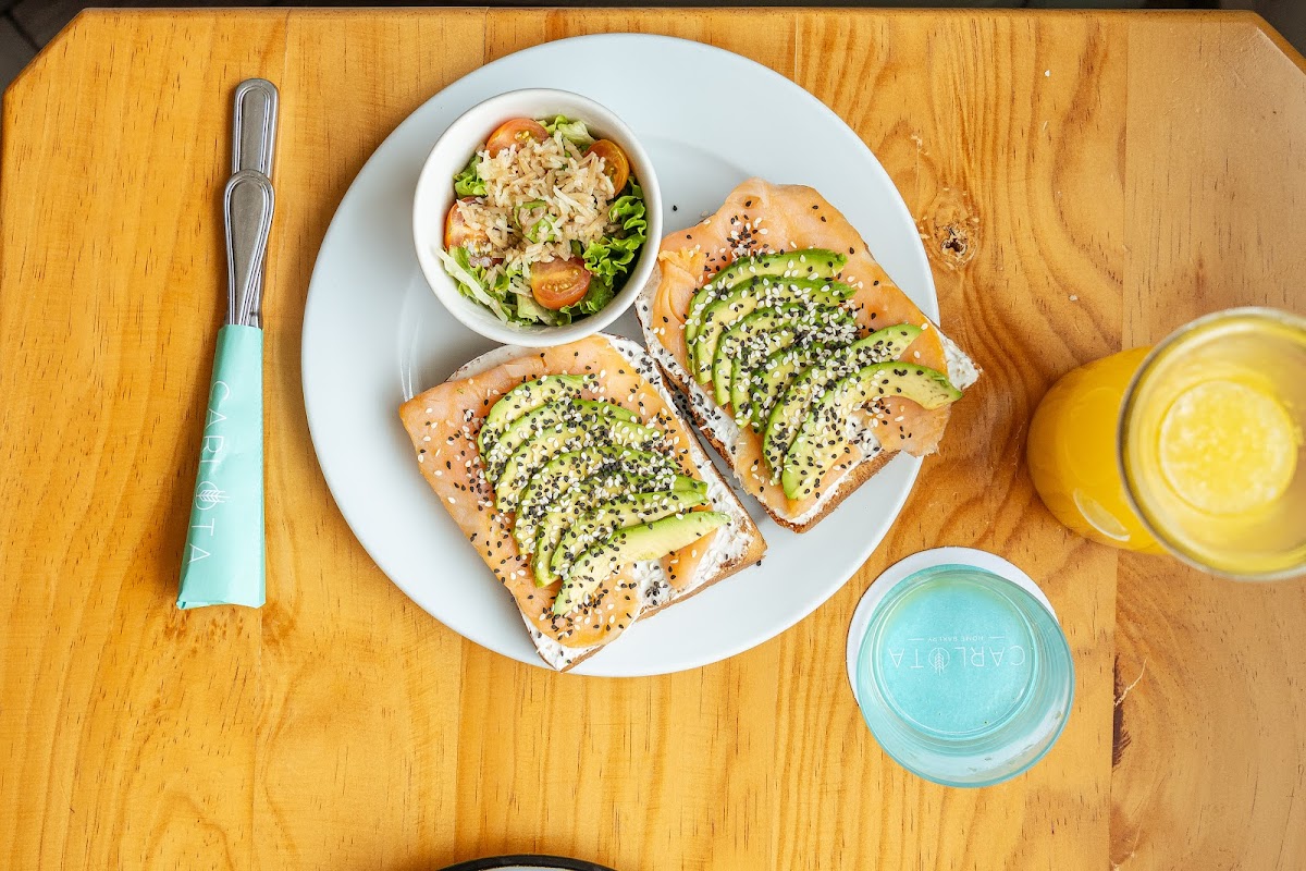 Avocado toast con huevo pochado y chile rojo en el mostrador de Carlota Home Bakery — primer plano del plato