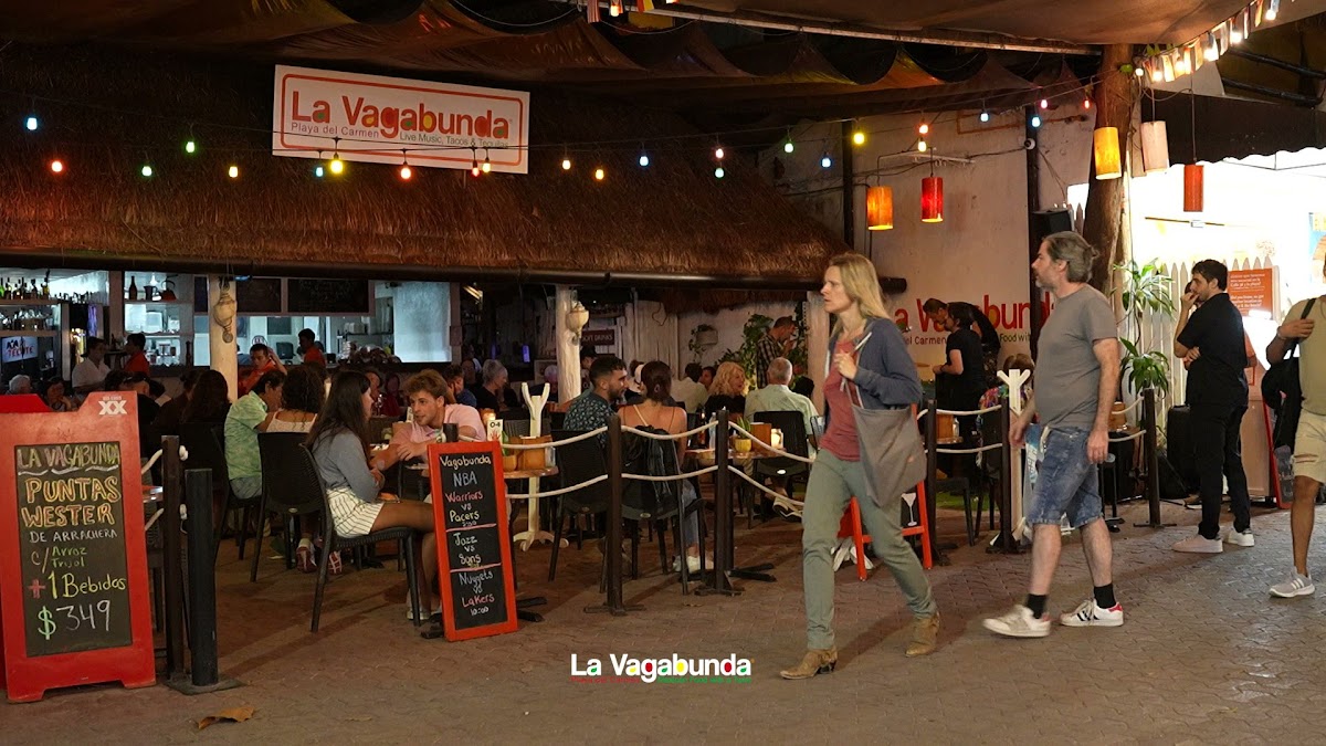 Plato de cochinita pibil y huevos motuleños en La Vagabunda, con fondo de la Quinta Avenida y luces de la tarde