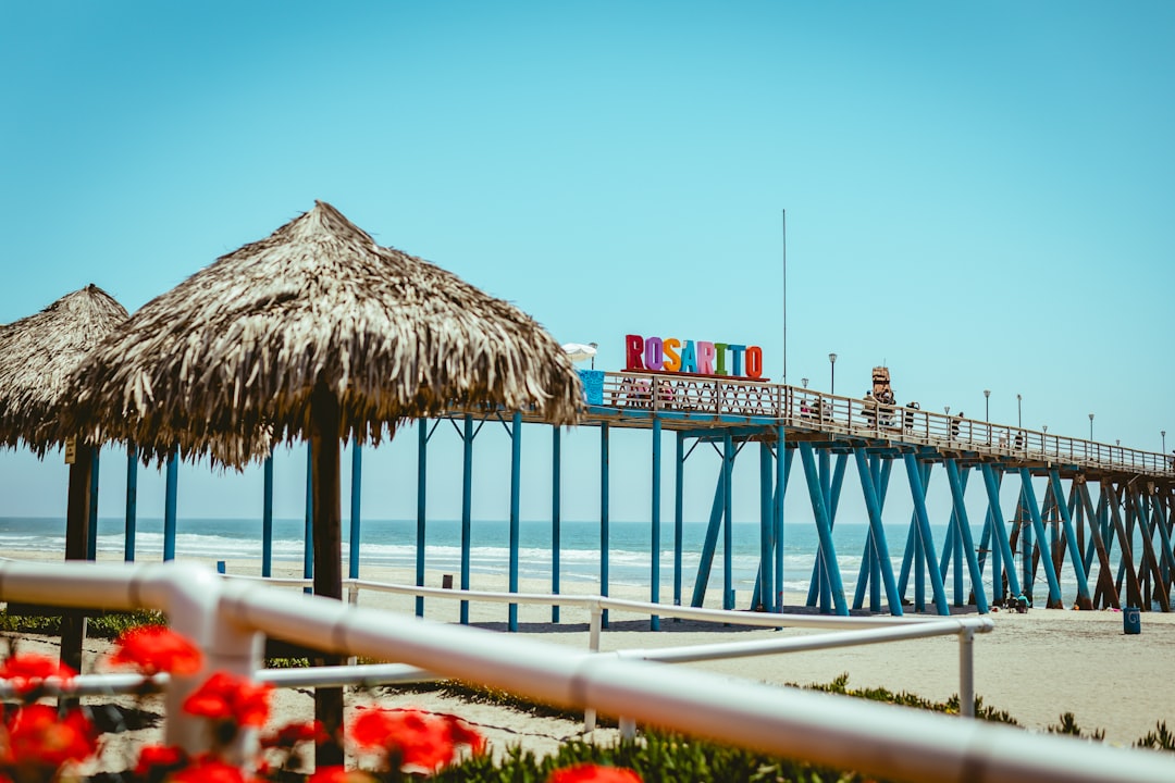 A pier in rosarito beach under a blue sky.
