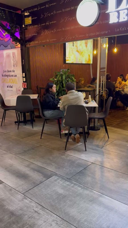 Interior de La Ka’z Restaurante Cholula con mesas ocupadas, ramen en primer plano y luces cálidas