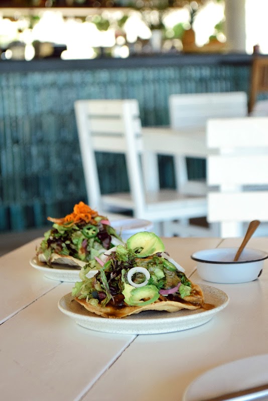 YAAB Vegan Kitchen & Café – plato de bowl de quinoa con verduras asadas y tacos de jackfruit en la mesa
