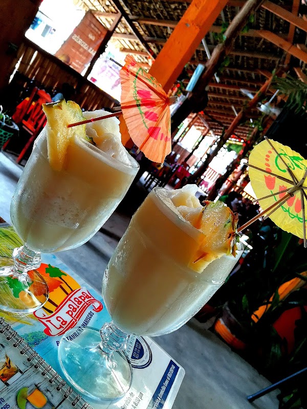 Restaurant y Mariscos La Palapa serving a plate of fresh ceviche on a wooden table, with lime wedges