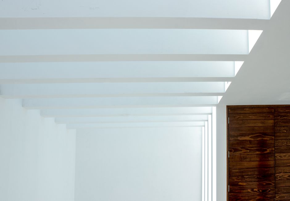 Elegant minimalist interior with geometric ceiling lights and wooden accents, creating a modern atmosphere.