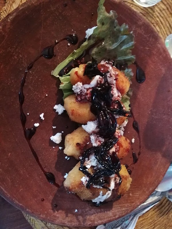 Café Restaurante Amuleto, mostrada su tarta de chocolate vegana sobre plato blanco, paredes con arte local