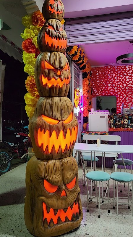 La Parrillada Azteca — fachada iluminada y una tlayuda con carne asada en primer plano