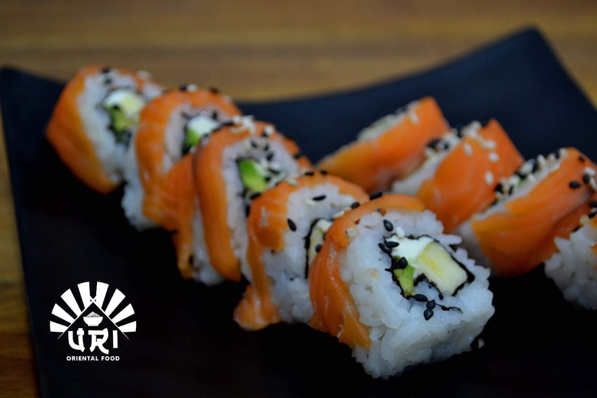 Interior del restaurante WABI‑SABI con barra de sushi, luces tenues y una bandeja de sushi nigiri sobre la mesa