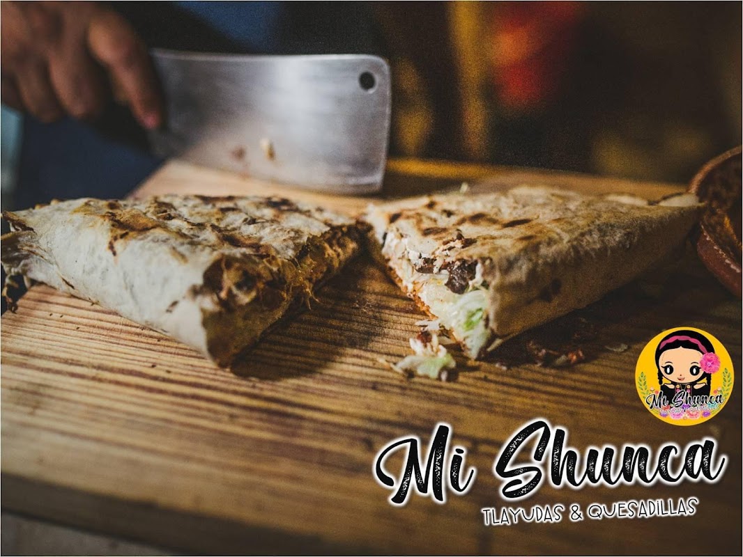 Plato de tlayuda en Mi shunca — vista cenital del taco grande con queso, frijoles y guacamole