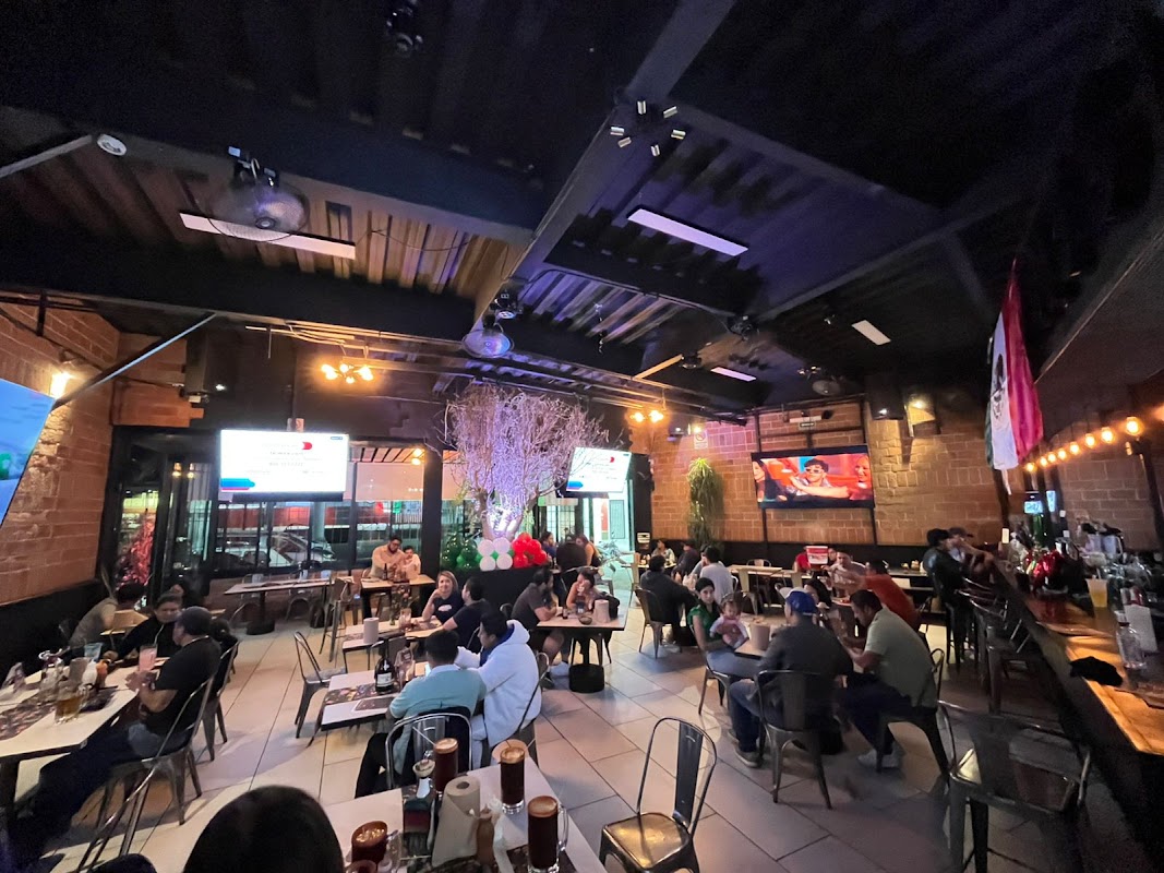Alitas crujientes y una michelada en Red Wings — primer plano del plato y la barra iluminada