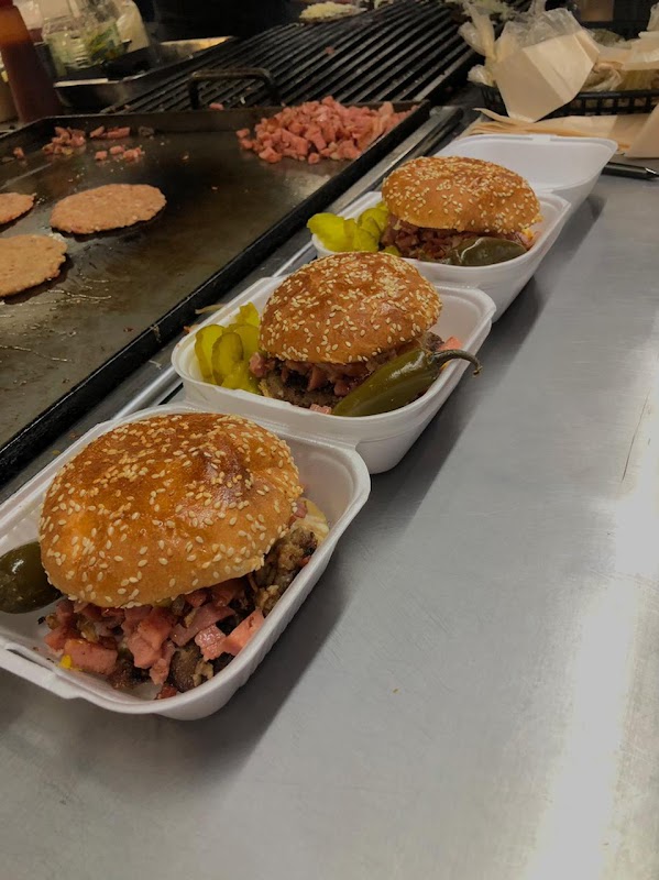 Primer plano de la hamburguesa Sevilla al carbón con piña caramelizada y salsa picante en el Crustaceo Cascarudo