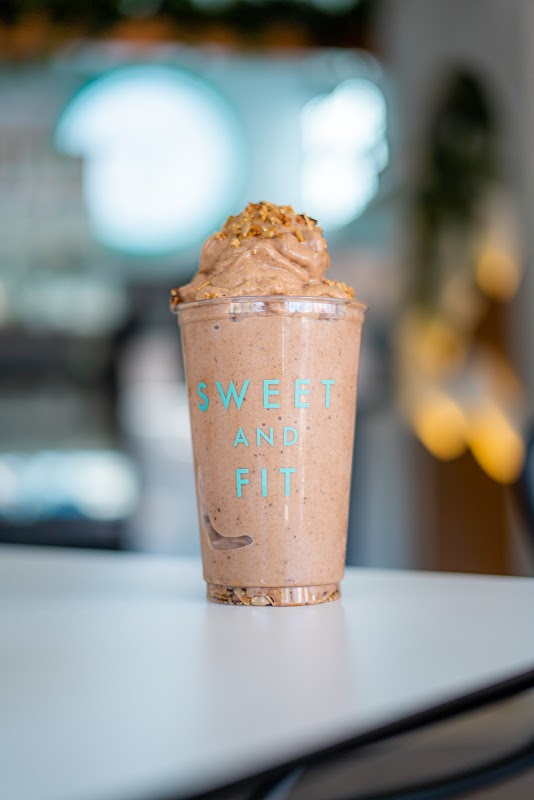 Smoothie de aguacate y espinaca en Sweet and Fit — vaso alto con hoja de menta al borde