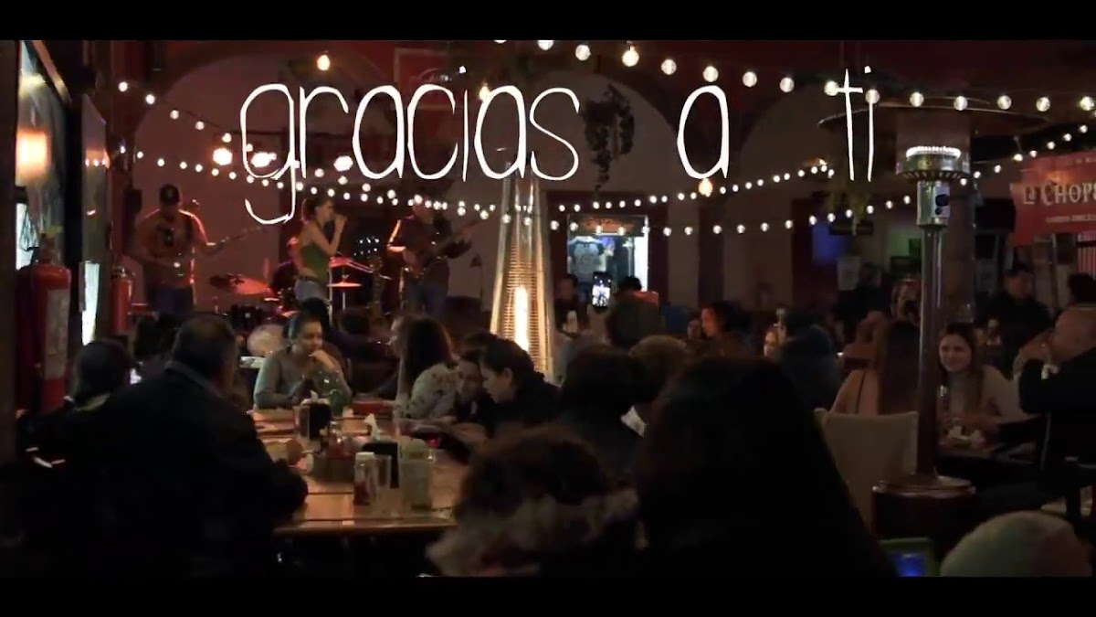 Interior de La Chope con gente cantando karaoke y una mesa de mezcal y mojitos — captura de ambiente nocturno
