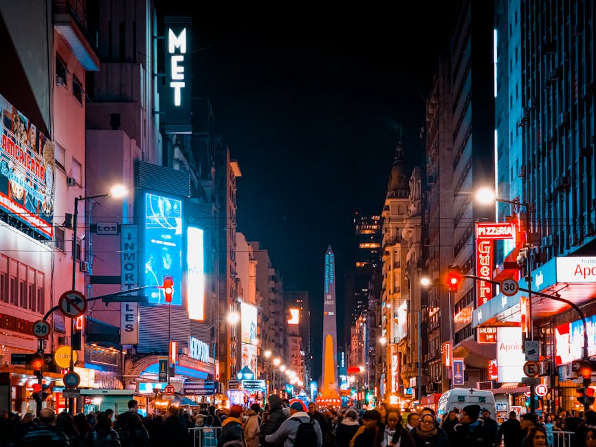 Vibrant night scene with colorful lights and crowded street in Buenos Aires, Argentina, featuring the iconic Obelisk.