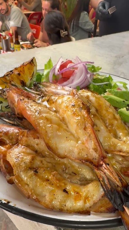 Ceviche de camarón en Mariscos Perihuete, plato principal con jugo de limón y guarnición de cilantro, vista del patio al aire libre
