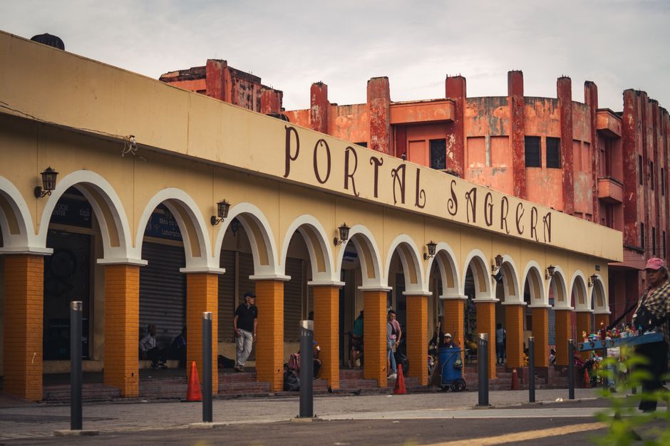 Colorful colonial-style arches at Portal Sagrera in San Salvador's bustling center capture vibrant city life.