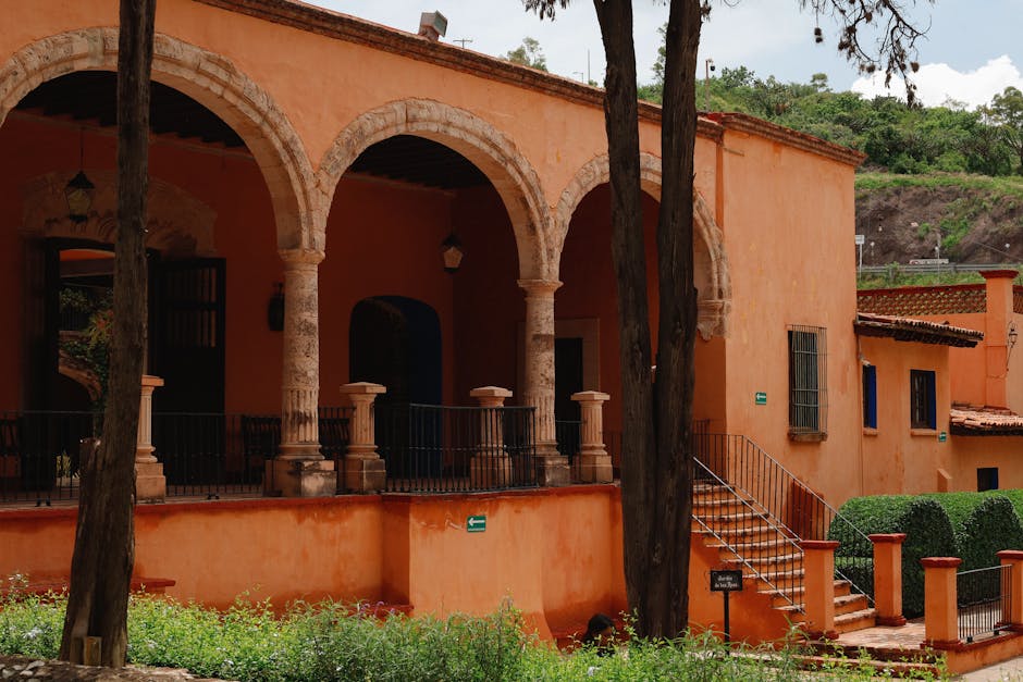 Charming arched courtyard of San Gabriel Hacienda in Guanajuato, Mexico, surrounded by lush greenery and summer ambiance.