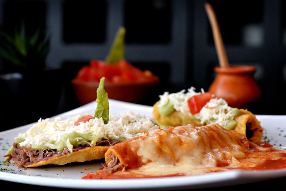 Vibrant Mexican enchiladas and tostadas topped with cheese and avocado, perfect for authentic dining.