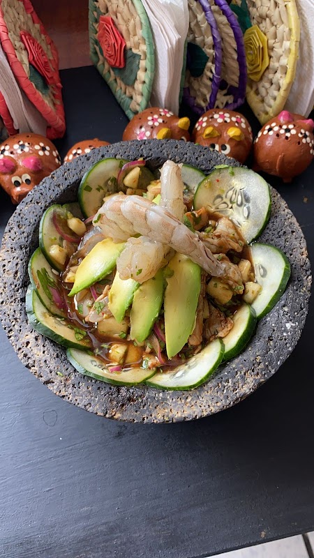 Mesa de FLOR TENEK CUISINE con tacos de carne y taza de café de olla, luz matutina