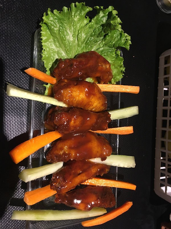 Cóctel de mezcal y parrilla de carne al carbón en Astral Food & Bar — ambiente nocturno con luces tenues