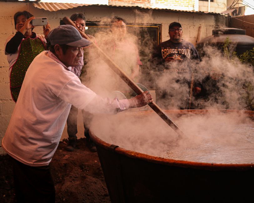 People cooking a traditional Mexican soup in a large cauldron in Santa Ana Chiautempan.