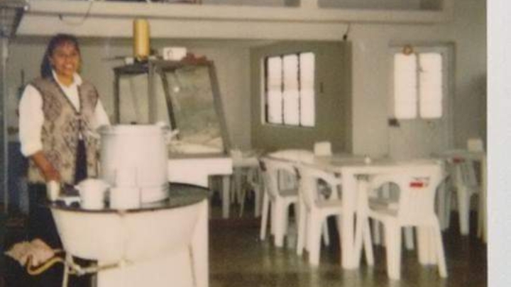 Interior de Café 406 con mesas de madera, clientes jugando a juegos de mesa y una taza de frapes sobre la barra