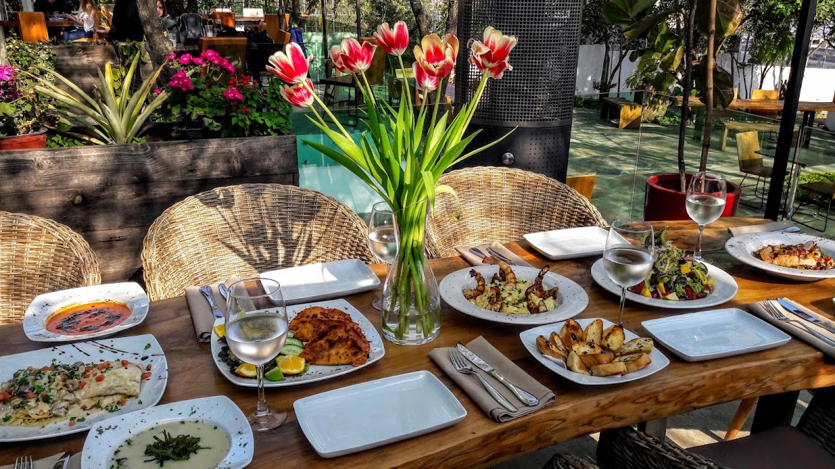 Terraza de El Traspatio Restaurante al anochecer, con tacos gobernador y costillas a la parrilla sobre la mesa