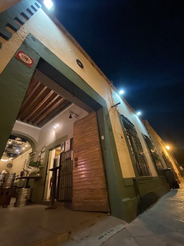 Área interior de Texas Roadhouse Querétaro con mesas de madera y la barra donde se preparan los cortes de carne