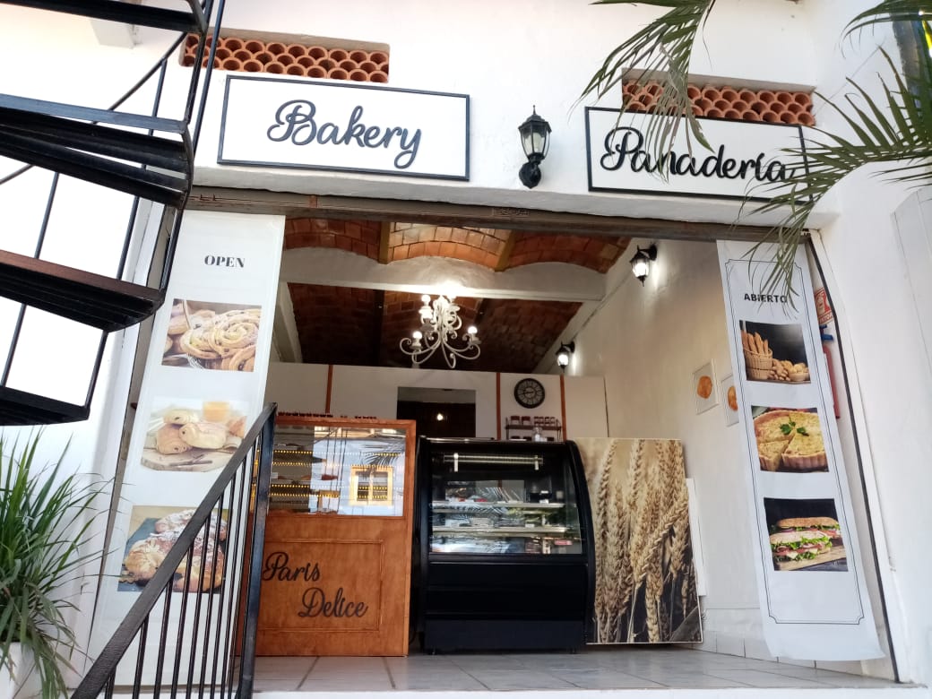 Paris Delights — vitrina con croissants de chocolate y una barra de baguettes, captura la luz matutina sobre los pasteles.