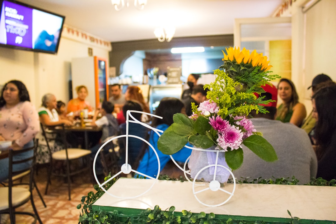 a vase with flowers on a table in a restaurant