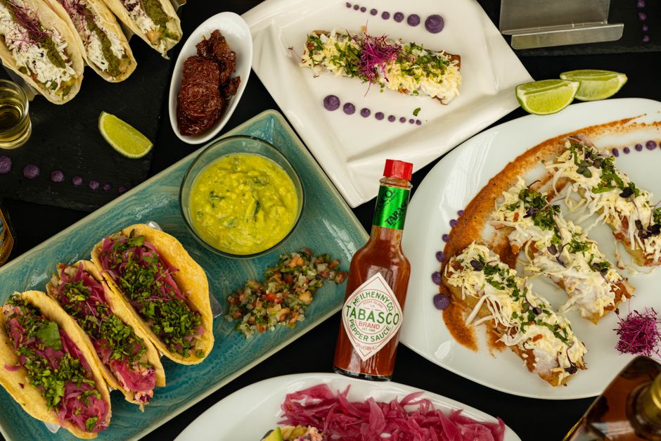 Colorful Mexican taco spread with Tabasco sauce highlights delicious flavors.