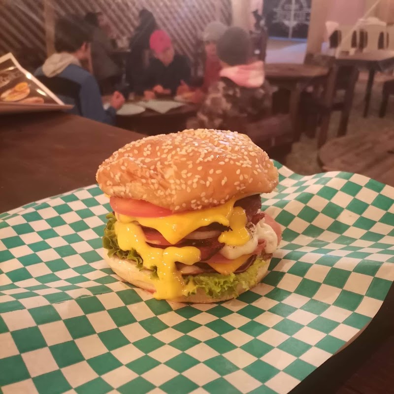 Restaurante bar BOCANEGRA mostrando una hamburguesa jugosa con papas fritas al fondo del mostrador