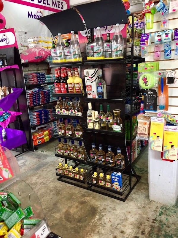 Pasillo de productos frescos en Maxy, con frutas tropicales y una caja de pan dulce al frente