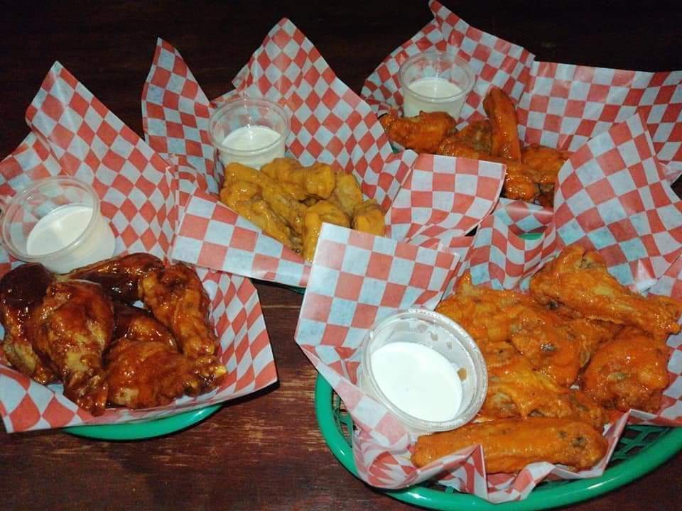 Interior de Lonchería San Antonio de Padua con mesas de madera, platos de frijoles y salsa picante en primer plano
