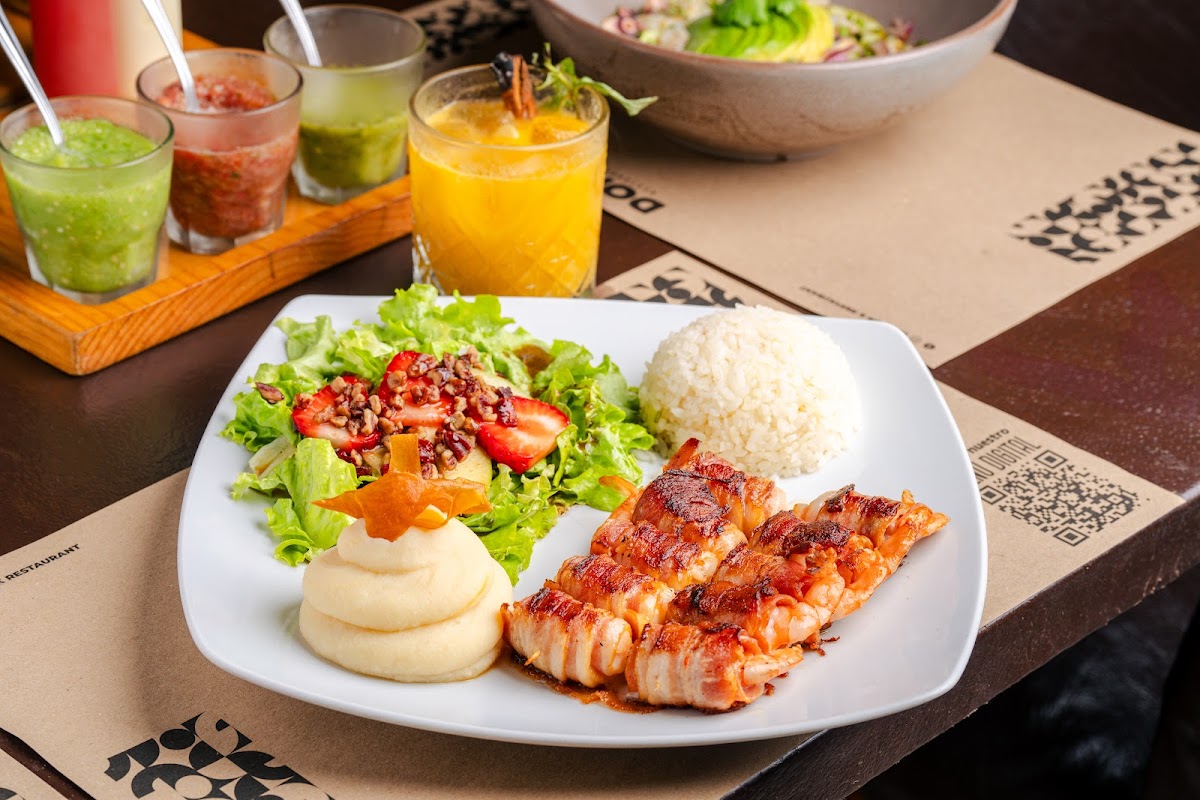 Barra y platos de El Ancladero, con parrilla de carne y ambiente nocturno