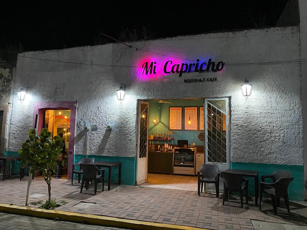 Taquería Flores con tacos de barbacoa en un plato de papel, letrero de neón al fondo